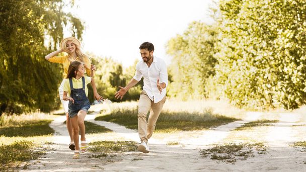 Ευτυχισμένη οικογένεια απολαμβάνοντας τα Σαββατοκύριακα και τρέξιμο στο μονοπάτι - Φωτογραφία, εικόνα
