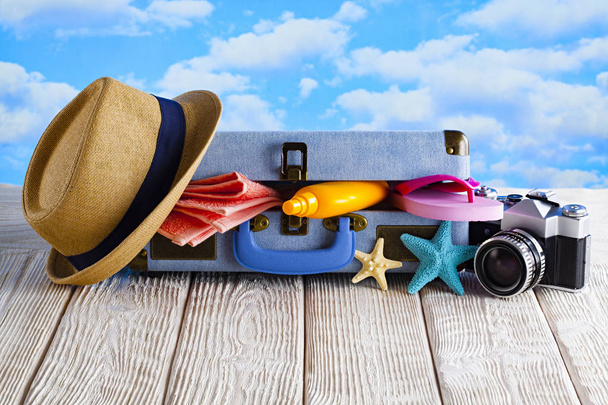 Open holiday suitcase; summer hat, towel, tanning oil, photo cam - Photo, Image