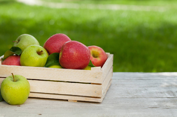 Manzanas verdes y rojas de jardín fresco en caja
 - Foto, imagen