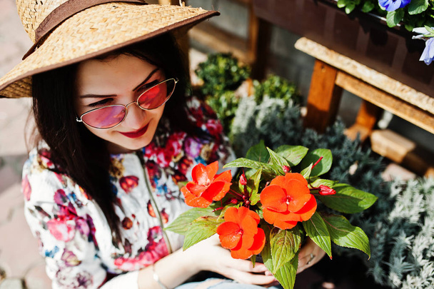 Summer portrait of brunette girl in pink glasses and hat against - Zdjęcie, obraz