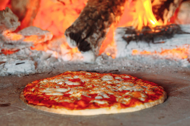 Brick oven with hot pizza cooking inside. - Photo, image