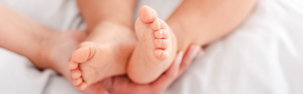 Plan panoramique de jolies petites jambes de bébé sur tissu blanc
 - Photo, image