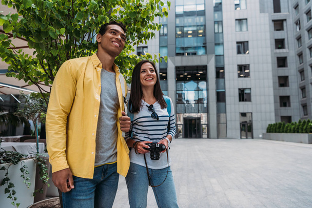 happy woman and mixed race man standing near building  - Photo, Image