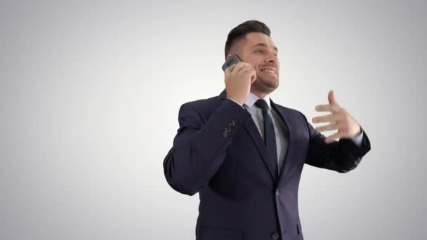 Businessman talking on mobile phone happily on gradient background. - Felvétel, videó