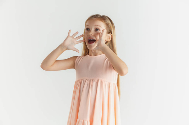 Little smiling girl posing in dress on white studio background - Foto, immagini