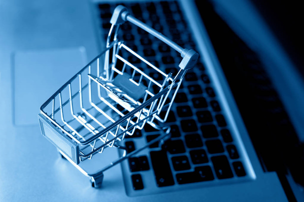 Concepto de negocio de comercio electrónico. carrito de compras en el teclado portátil
. - Foto, Imagen