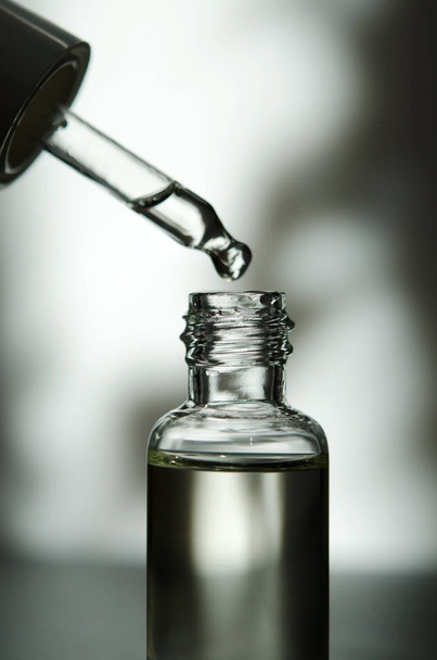 Cosmetic or medical glass bottle with pipette. Skin care concept. Natural hard light, deep shadows. - Image - 写真・画像