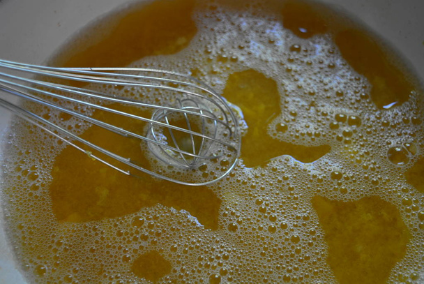 Batedor de cozinha metálica em um caldo de damasco de fruto, um kampot de damasco fresco de geleia de fruto /
 - Foto, Imagem