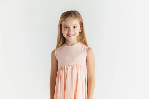 Little smiling girl posing in dress on white studio background - Fotoğraf, Görsel