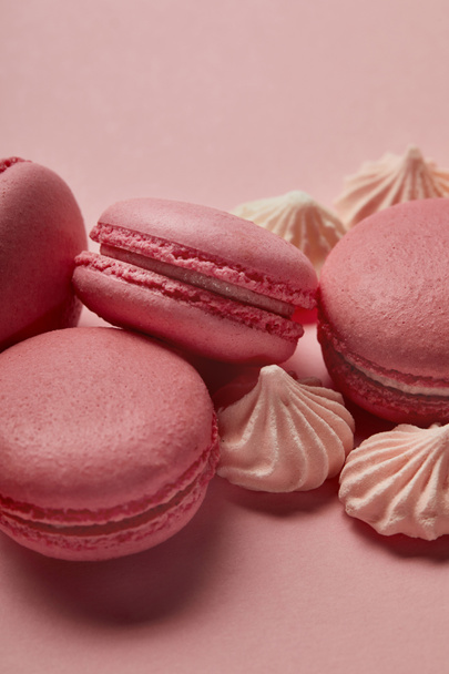 Pink macaroons with small meringues on pink background - Fotografie, Obrázek