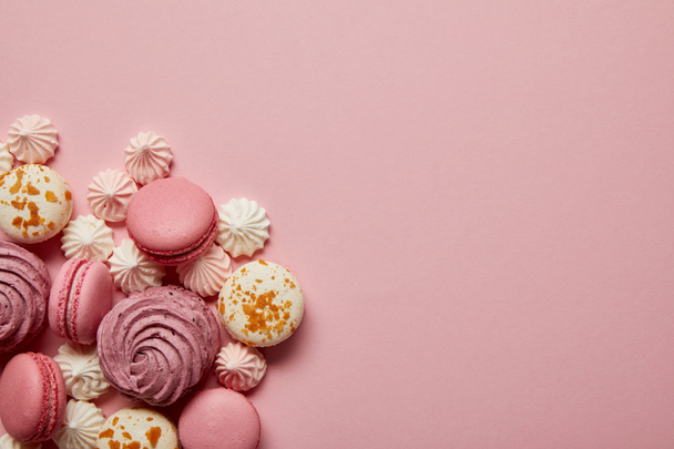 Delicious sweet pink and white macaroons with meringues on pink background - Photo, Image