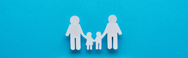 panoraama laukaus paperi leikkaa perheen pitämällä kädet sinisellä pohjalla
 - Valokuva, kuva