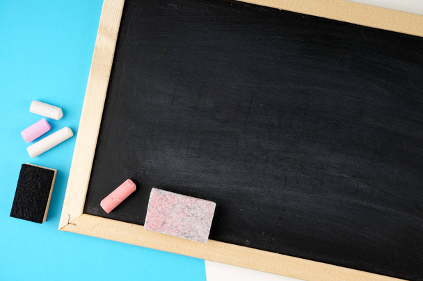 empty space on black board and colorful chalks and sponges - Photo, image