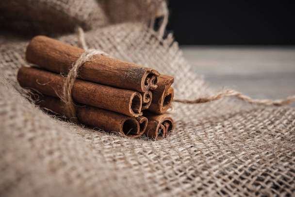 Cinnamon sticks on wooden background. - Foto, imagen