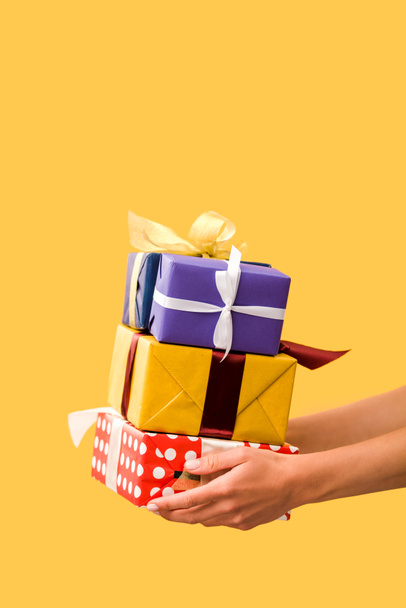 cropped view of girl holding presents in hands isolated on yellow - Photo, Image