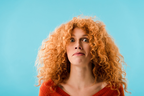 portrait of shocked redhead woman isolated on blue - Photo, Image