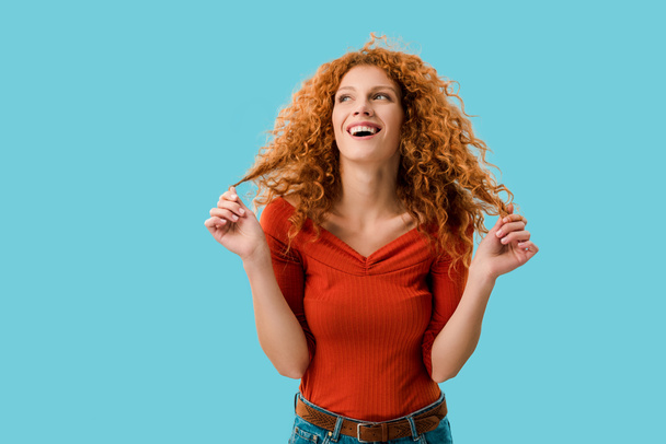 portrait of laughing redhead girl isolated on blue - Photo, Image