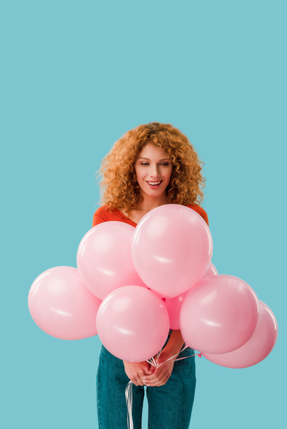 happy redhead woman with pink balloons isolated on blue - Foto, imagen