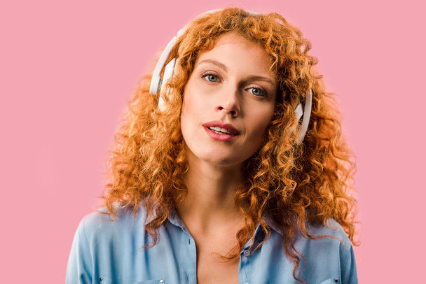 redhead woman listening music in headphones, Isolated On pink - Foto, Bild