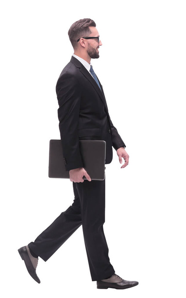 in full growth. successful businessman with laptop stepping forward. - Foto, imagen