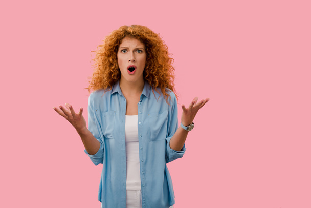 mooie boze redhead vrouw schreeuwen geïsoleerd op roze   - Foto, afbeelding