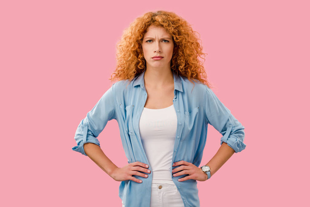 attractive redhead girl in bad mood isolated on pink - Photo, Image