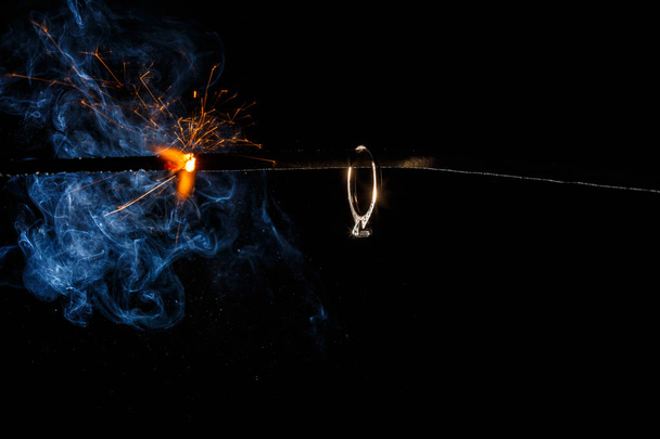 Обручальное кольцо на горящем бенгальском свете
 - Фото, изображение