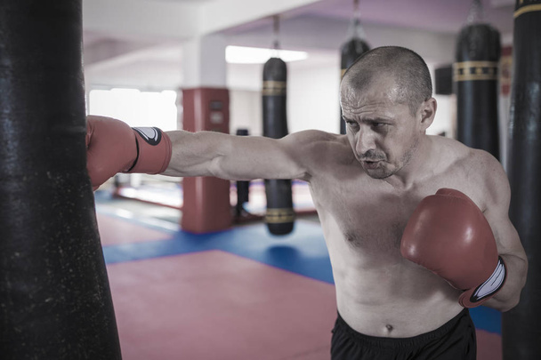 Muay thai combattant frapper le sac lourd dans la salle de gym
 - Photo, image
