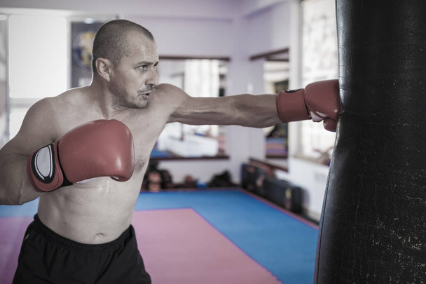 Muay thai lutador batendo o saco pesado no ginásio
 - Foto, Imagem
