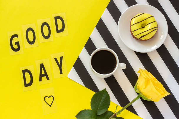 Text Good day Coffee, Donut, yellow rose on stylish black and white napkin on yellow background - Photo, Image