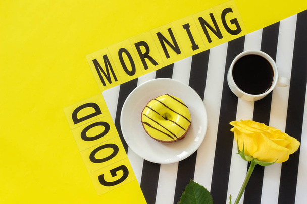 Text Good day Coffee, Donut, yellow rose on stylish black and white napkin on yellow background - Fotó, kép