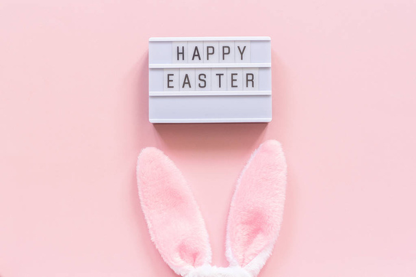 Light-box with text Happy Easter and bunny ears on pink paper background - Fotoğraf, Görsel