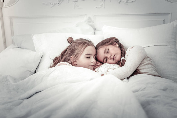 Adoráveis meninas pequenas dormindo na cama juntos
 - Foto, Imagem
