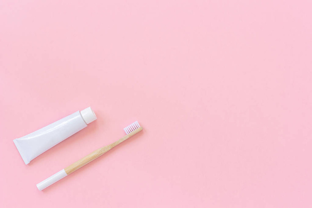 Natural eco-friendly bamboo brush with white bristles and tube of toothpaste - 写真・画像
