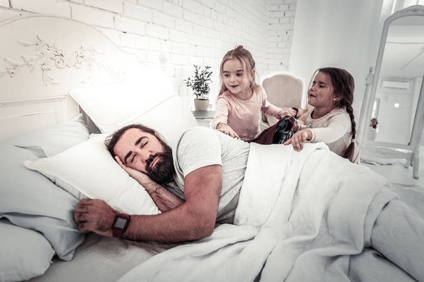 Cute girls waking up their father in the morning - Fotó, kép