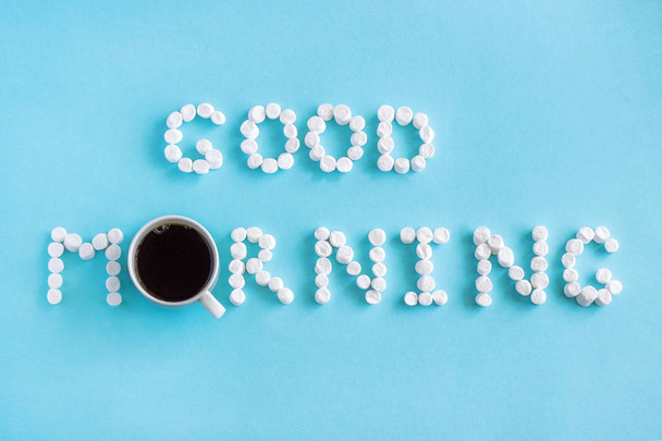 Text Good Morning from marshmallow and cup of coffee on blue background - Foto, Imagem
