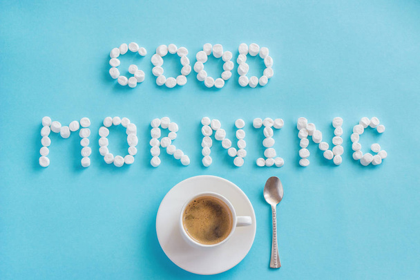 Text Good Morning from marshmallow and cup of coffee on blue background - Photo, Image