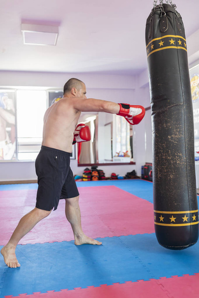 Muay thai harcos ütő az edzőteremben nehéz táska - Fotó, kép