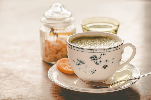 зелений чайний мачан соєвий латте в чашці з китайським цукром і склянкою води збоку
 - Фото, зображення