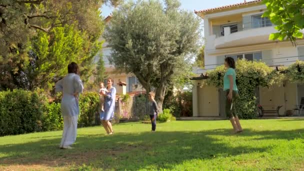 Drei Generationen haben Spaß bei Übungen auf grünem Gras im Garten. Erwachsene und Kinder sorgen sich um ihre Gesundheit. Yoga-Fitness-Übungen auf der Villa in der Nähe des Meeres. Zeitlupe - Filmmaterial, Video