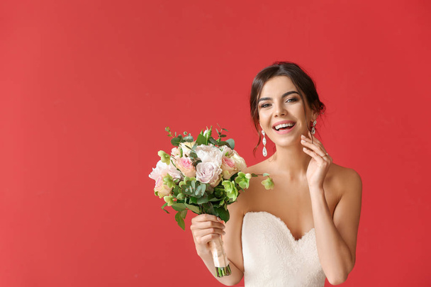 Beautiful young bride with bouquet of flowers on color background - Photo, Image