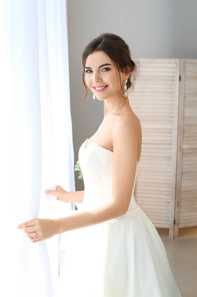 Beautiful young bride near window at home - Foto, Imagem