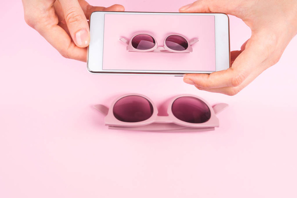 Różowe okulary przeciwsłoneczne w ręce kobiety - Zdjęcie, obraz