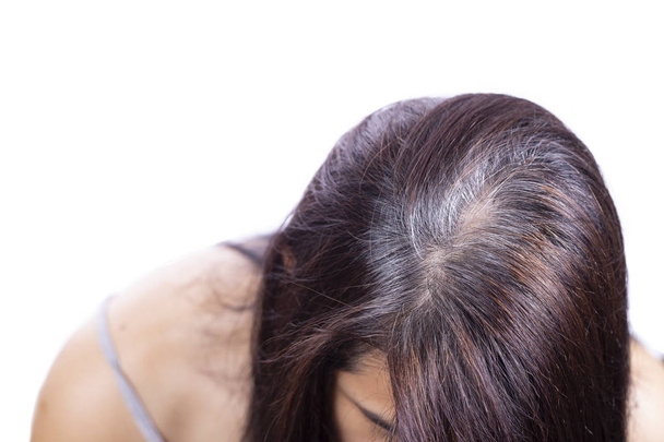 junge Frau zeigt ihre grauen Haarwurzeln, isoliert und weiß - Foto, Bild