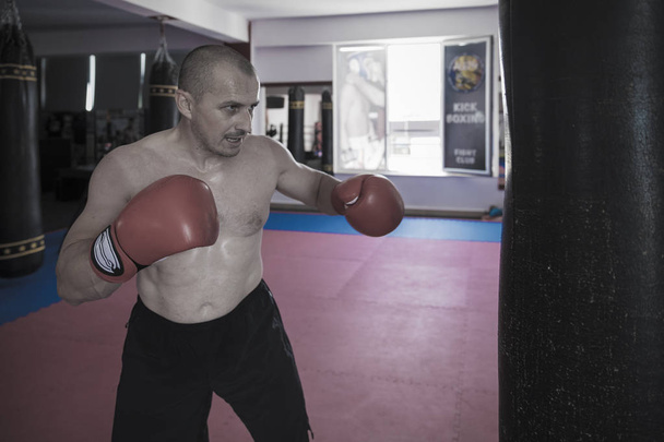 Muay thai fighter hitting the heavy bag in the gym - Photo, Image
