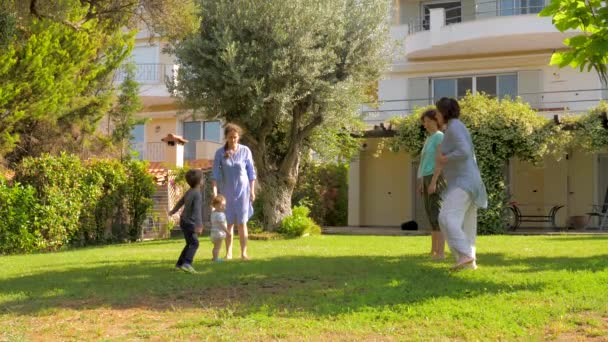 豪華な家、ヴィラの前庭でスローモーションでジャンプ幸せな家族。夏休みのコンセプト。新鮮な空気の上に家族、健康的なレクリエーションやスポーツと夏休み - 映像、動画