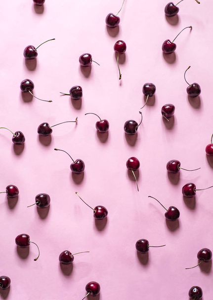 lovely flatlay on pink background with cherries - Foto, afbeelding