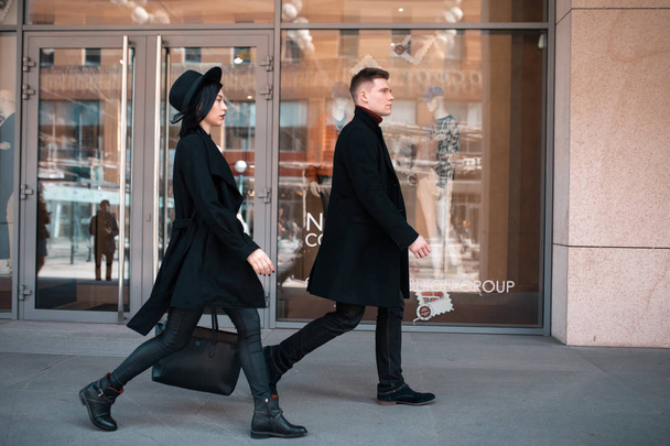 un homme en noir et une femme en noir s'approchent du magasin
 - Photo, image