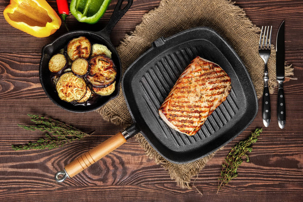 Grilled striploin on grill pan and fried eggplant on wooden background - Photo, Image