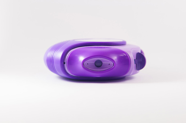 paarse poeder astma-inhalator op witte achtergrond - Foto, afbeelding